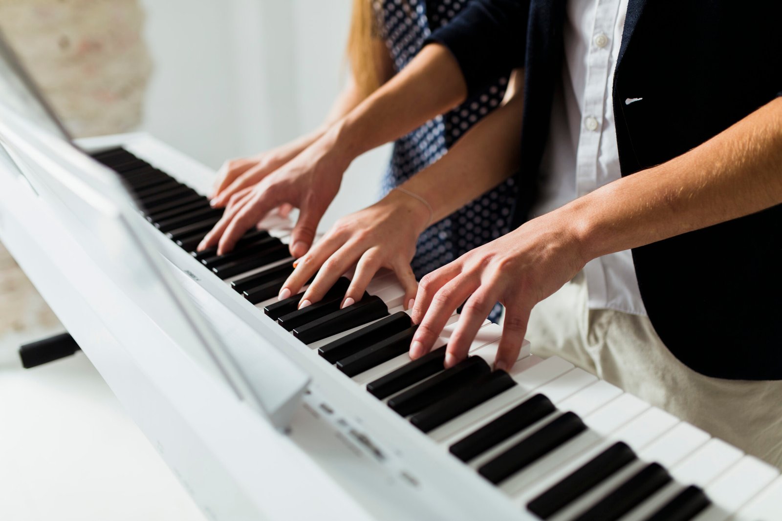 close-up-couple-s-hand-playing-piano-keyboard