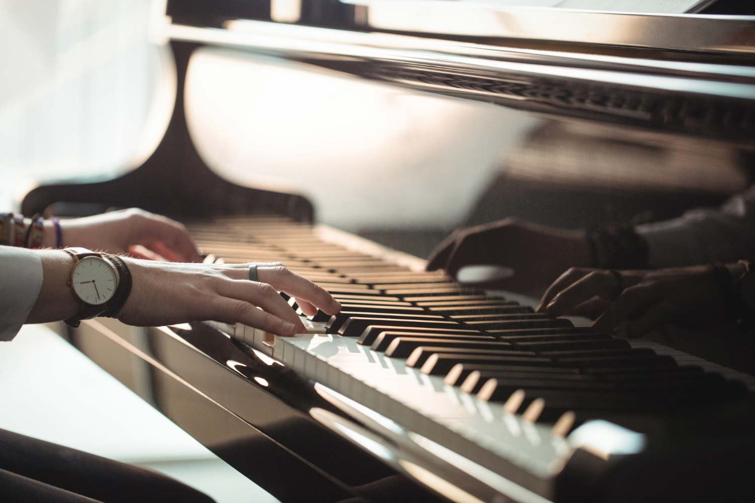 Mains jouant du piano grâce à la méthode visuelle par couleurs